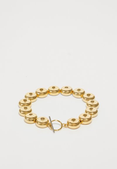 Bracciale in metallo dorato con una serie di anelli circolari lucidati e chiusura a gancio. Finitura liscia e lucida in tutto.