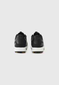 Pantofi sport negri cu un material neted, formă rotunjită, talpă albă în contrast și caracteristici de tracțiune din cauciuc pe talpa exterioară.