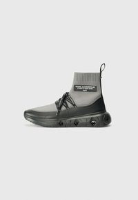 Gray and black ankle-high sneaker with knit upper, drawstring closure, and textured sole featuring diamond patterns and logo accents.