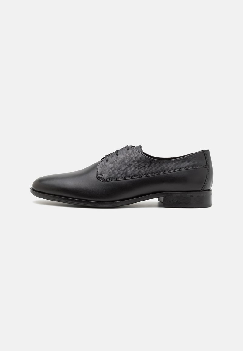 Black leather dress shoe featuring a sleek design, pointed toe, five eyelet lace-up closure, and a smooth texture with a low heel.