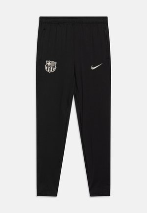Pantalons de sport noirs en tissu lisse, avec le logo du FC Barcelone et un swoosh Nike argenté, dotés d'une taille élastique et de poches.