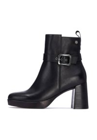 Bota de cuero negra con tobillo, con tacón grueso, cremallera lateral y detalle de correa ajustable con hebilla. Acabado suave y diseño de punta redonda.