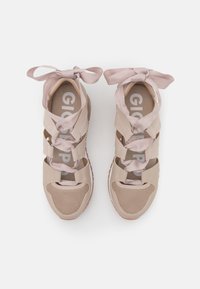 Baskets beige clair avec des détails en mesh et des lacets en satin rose doux, dotées d'une semelle intérieure rembourrée et d'une semelle en caoutchouc pour une bonne adhérence.