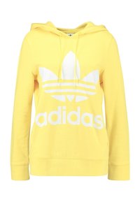 Gul bomullshoodie med en stor vit Adidas-logotyp och tre horisontella ränder i mitten. Inkluderar en framficka och justerbar huva.
