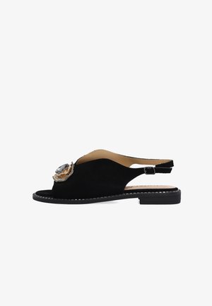 Zwarte suède slingbacksandaal met lage blokhak en grote decoratieve edelsteen en gouden versiering op het voorste bandje.