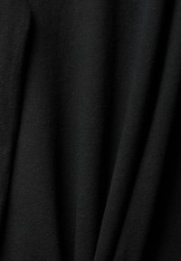 Tessuto nero con una consistenza morbida e liscia, caratterizzato da un aspetto leggero e leggermente drappeggiato con pieghe sottili e senza motivi visibili.