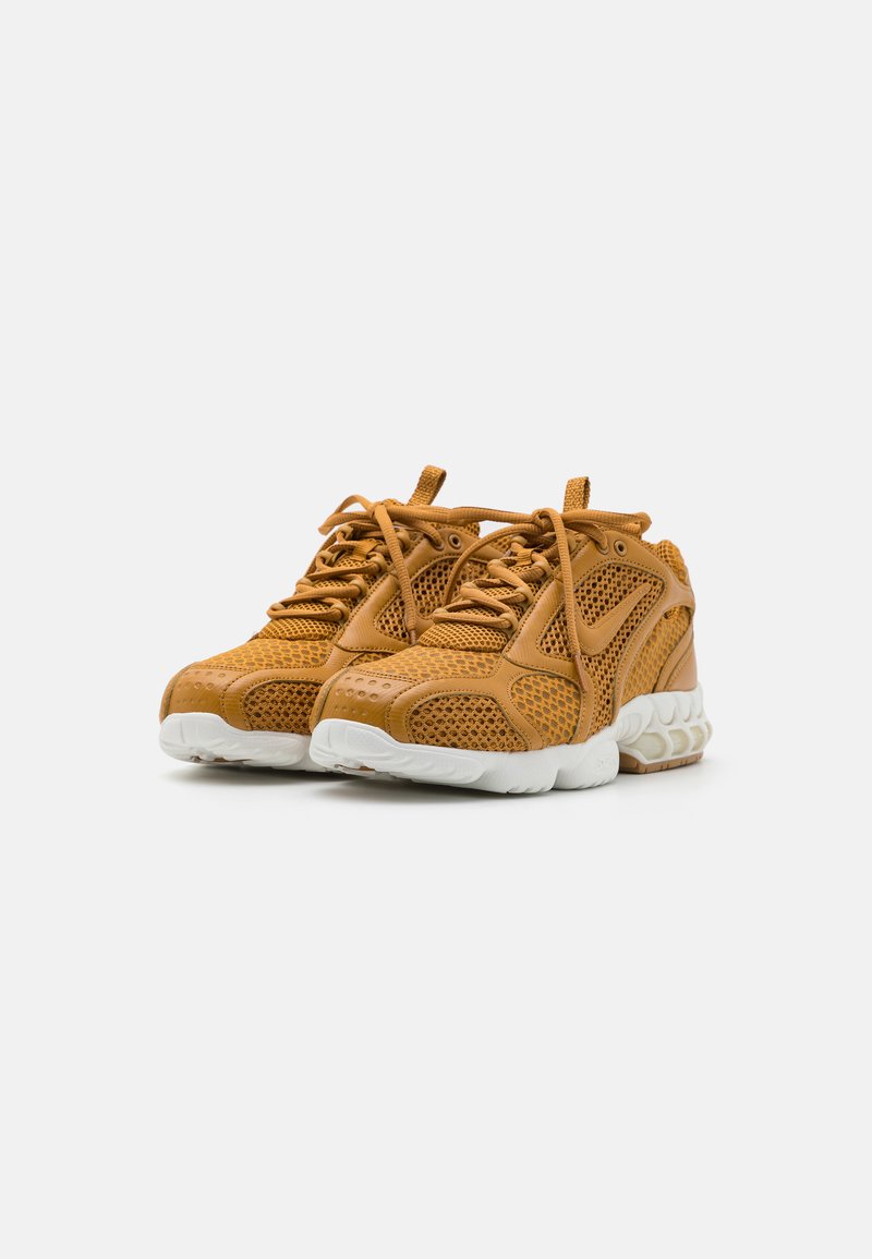 Baskets en maille et cuir beige avec un design à lacets, dotées d'une semelle en caoutchouc blanc et d'accents perforés pour la ventilation.