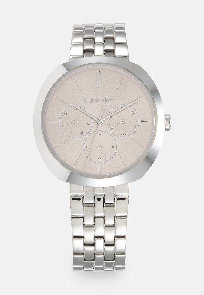 Sølv rustfritt stål klokke med rund urskive, beige skive, tre sub-dials og lenkebånd. Har minimalistiske timemarkører.