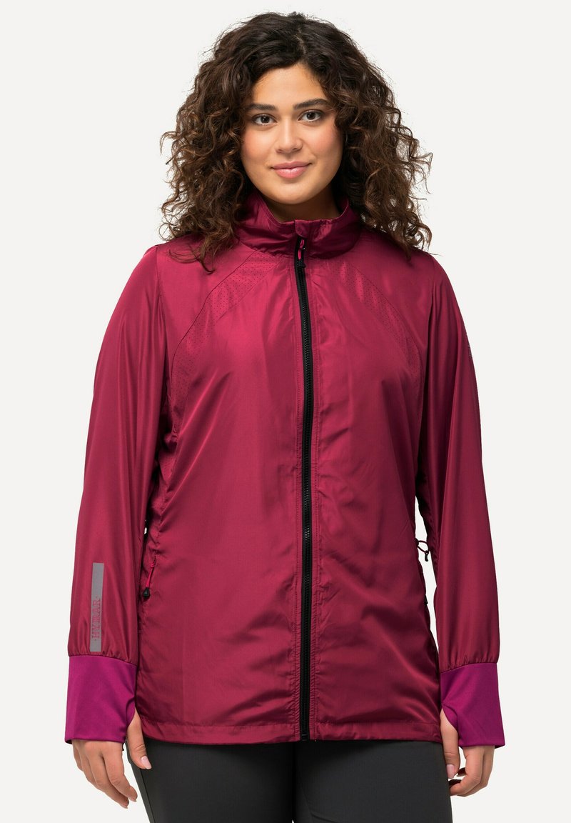 Burgundin kevytrakenteinen takki, jossa on korkea kaulus, vetoketjukiinnitys, joustavat hihansuut ja säädettävät sivuyksityiskohdat. Sisältää teksturoituja paneeleja hengittävyyden parantamiseksi.