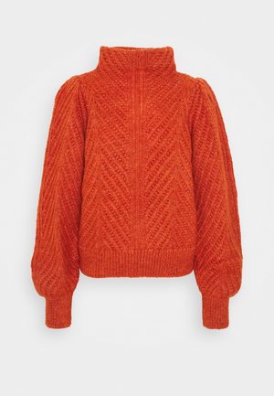 Oranssi neulottu paita korkealla kauluksella, chevron-kuviolla, pöhöttyneillä pitkillä hihoilla sekä resoreilla hihoissa ja helmassa.