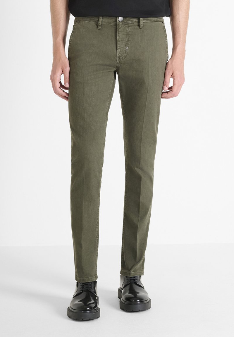 Pantalones ajustados verde oliva, fabricados en algodón con una textura suave, que cuentan con cierre de botón y cremallera, bolsillos laterales y un diseño limpio.