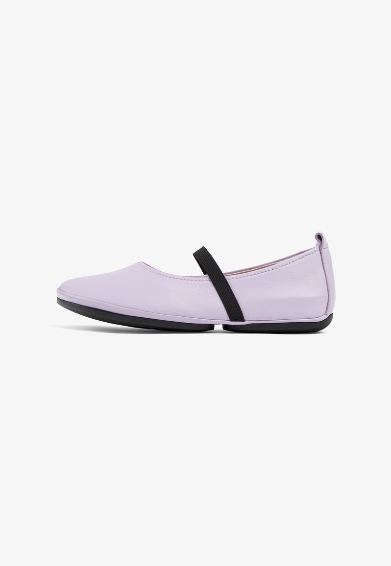 Chaussure plate lilas avec bout arrondi, bande élastique noire sur le milieu du pied et semelle en caoutchouc noire, vue de côté sur fond blanc.