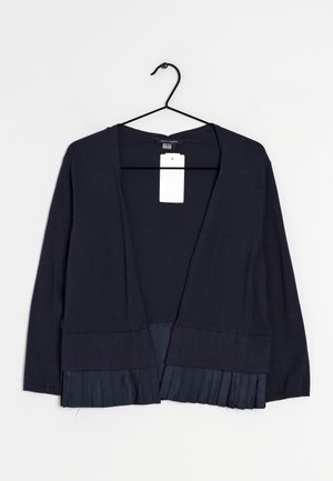 Granatowy kardigan z otwartym przodem, długimi rękawami i plisowanym detalem na dole, wiszący na czarnym wieszaku z białą metką.