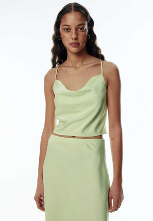 Helles grünes Satin-Top mit rundem Ausschnitt, dünnen Spaghetti-Trägern und glatter Textur, ergänzt durch einen passenden Rock.