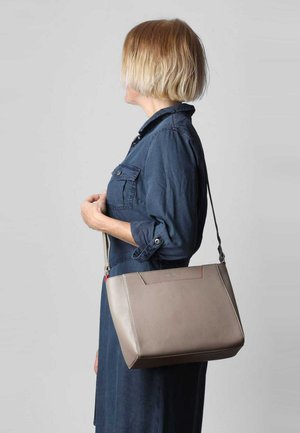 Helle graue Schultertasche aus glattem Leder in strukturierter Form, mit einem dezenten Steppnaht-Detail und einem verstellbaren Tragegurt.