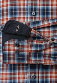 Geruit overhemd met rode, blauwe en crèmekleurige tinten. Gemaakt van katoen met een button-down kraag en een denim detail aan de manchetten. Vier zwarte knopen.