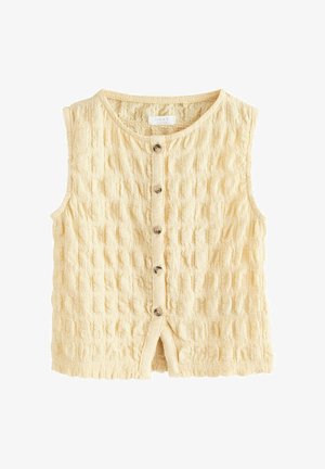Haut beige sans manches avec texture, boutonné sur le devant, col rond et cinq boutons au centre.