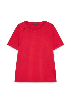 Camiseta de algodón roja con cuello redondo, mangas cortas y tres botones dorados en el hombro izquierdo. Textura suave.