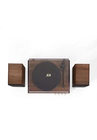 Platine en bois avec un plateau noir, un couvercle en verre transparent et des accents dorés. Deux haut-parleurs en bois assortis de chaque côté.