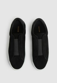 Scarpe slip-on in suede nero con inserti elastici, punta arrotondata e suola bianca a contrasto. Logo "REISS" in oro sulla soletta.