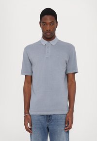 Gray polo shirt with short sleeves, three-button placket, and subtle logo embroidery. Lightweight fabric with a smooth texture.
