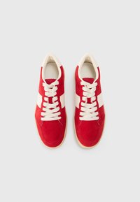 Baskets en daim rouge avec des rayures en cuir blanc, bout rond et semelle en caoutchouc beige. Comprend des lacets blancs et un col rembourré.