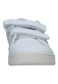 White sneaker with a smooth synthetic upper, two adjustable Velcro straps, and a textured white rubber sole. Clean, minimalist design.