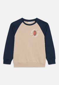 Sweatshirt de manga raglan bege e azul-marinho com "Futebol Americano ESTD 1999" e gráfico de futebol no peito.