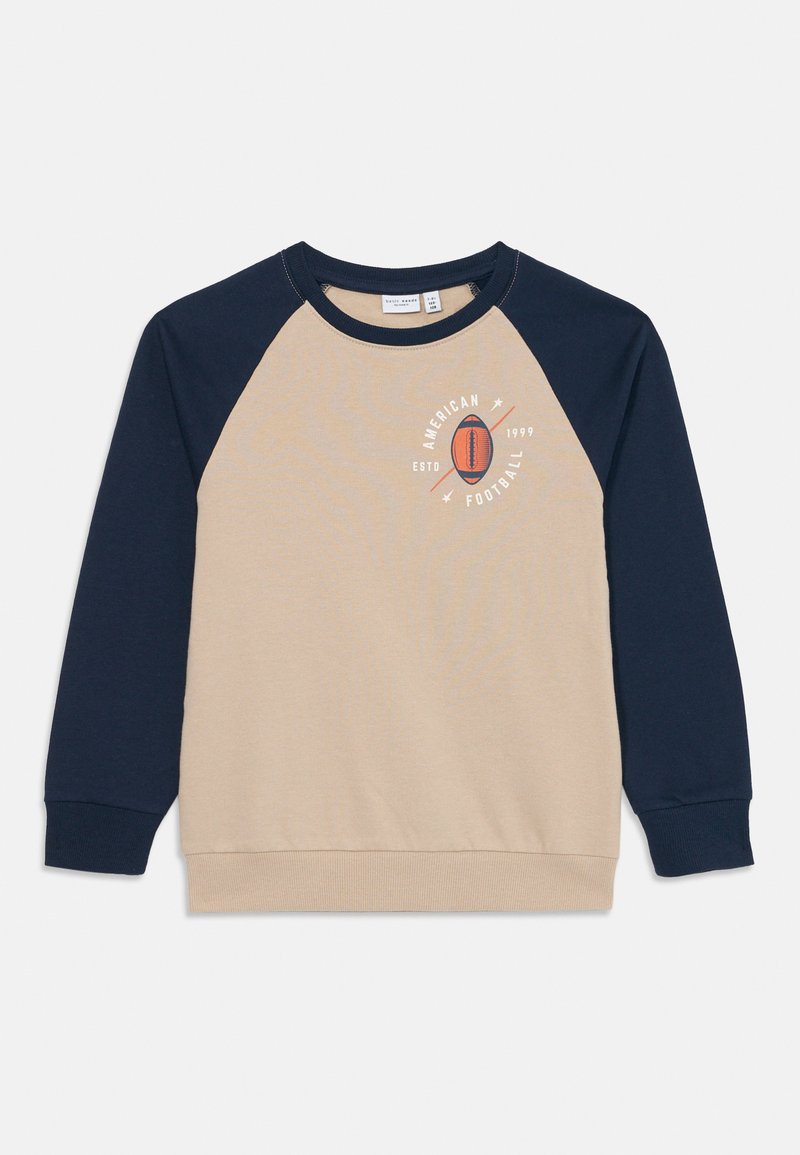 Sweatshirt de manga raglan bege e azul-marinho com "Futebol Americano ESTD 1999" e gráfico de futebol no peito.
