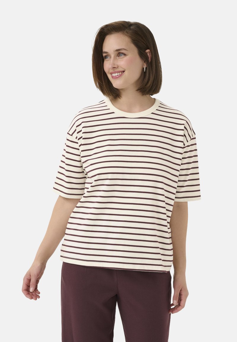 Striped t-shirt in cream with maroon horizontal stripes, featuring a round neckline and short sleeves, paired with dark pants.