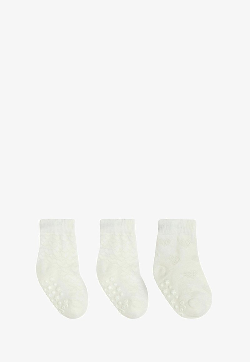 Białe skarpetki do kostek z teksturowanym wzorem, ściągaczem i antypoślizgowymi punktami na podeszwie. Trzy pary wyeksponowane w rzędzie.