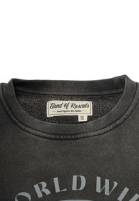 Tumma harmaa huppari pyöreällä kaula-aukolla, pehmeä tekstuuri, jossa on kevyesti harmaalla painettu "WORLD WIDE" -design. Tunnuksessa lukee "Band of Rascals."