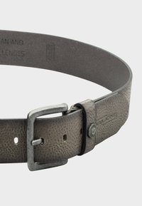 Leren riem in donkergrijs met een gestructureerd oppervlak. Voorzien van een zilveren metalen gesp en gaatjes voor maatverstelling, met een robuust ontwerp.