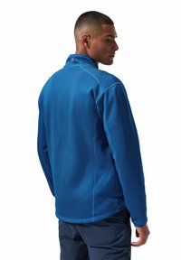 Blauer Fleece-Pulloverjacke aus strukturiertem Material, mit hohem Kragen und kontrastierenden Nähten. Sie hat eine slim fit Passform und lange Ärmel.