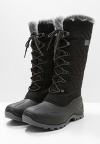 Černé nepromokavé zimní boty s prošívaným materiálem, imitací kožešiny na okraji, šněrováním a texturovanou gumovou podrážkou pro lepší přilnavost.