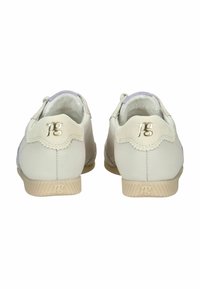 Zapatos de cuero blanco con interior suave, detalles en color púrpura claro, bordes ondulados y logo en el talón y lateral. Suela de goma.