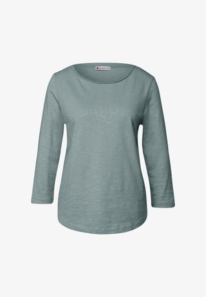 Jasnoniebiesko-zielona koszula z długim rękawem o szerokim dekolcie w serek, wykonana z miękkiego, teksturowanego materiału. Posiada zaokrąglony dół i ściągacze przy rękawach.