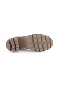 Shoe sole featuring a textured rubber material in light beige, with deep treads for traction and a smooth, slightly rounded toe area.