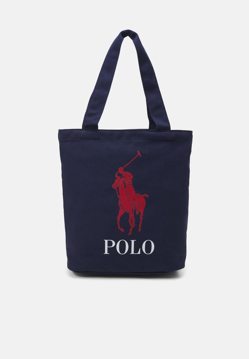 Geantă de umăr din canvas albastru marin, cu un grafic roșu de jucător de polo și textul alb "POLO" pe față. Mânere duble pentru o transportare ușoară.