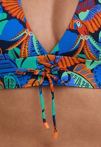 Top bikini colorato con scollatura profonda a V, stampa tropicale nei colori blu, verde, arancione e rosso, con spalline regolabili legate per una vestibilità sicura.