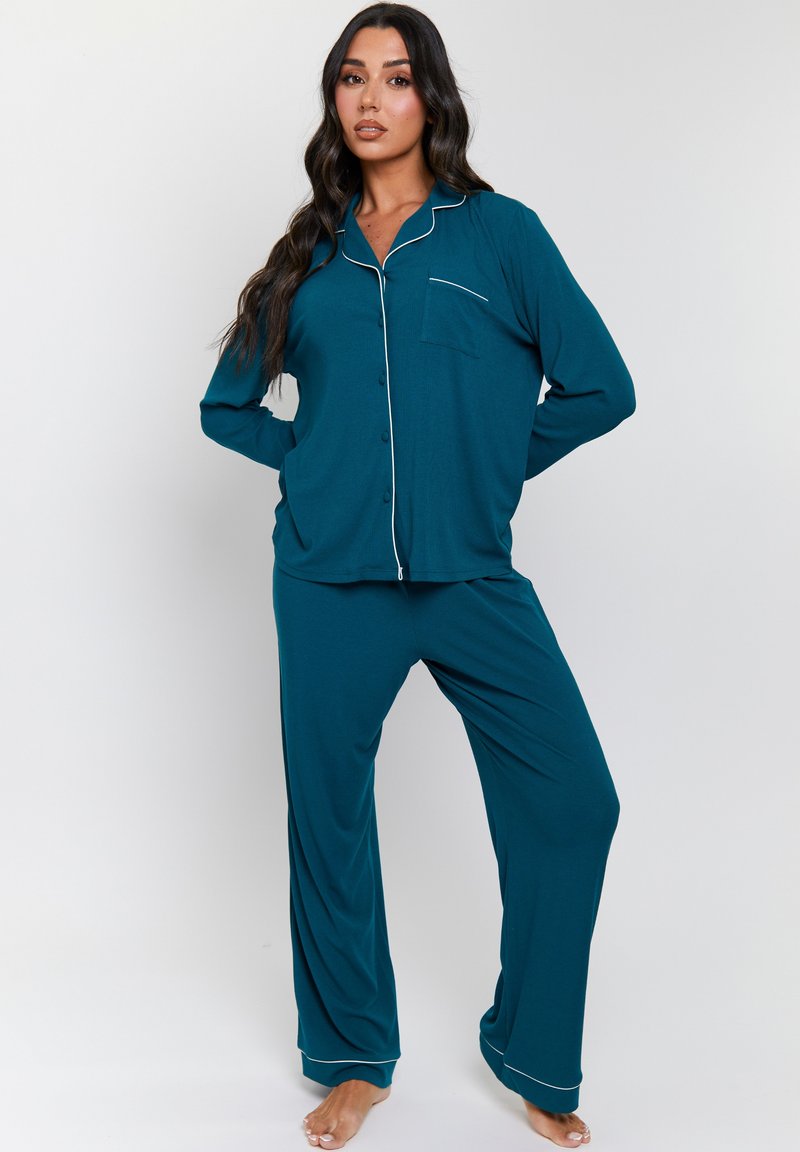 Teal pajama set made of soft fabric, featuring a button-up top with a pocket and contrasting white piping, paired with relaxed-fitting pants.