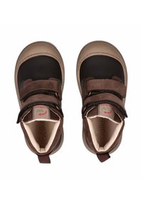 Bruine leren schoenen met zwarte accenten, klittenbandsluitingen, ronde neus en een rubberen zool. Zachte voering en lusje voor gemakkelijk aan- en uittrekken.