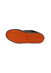 Black skate shoe sole with an orange textured rubber bottom, featuring a grid pattern and a central logo. Flat profile with rounded edges.