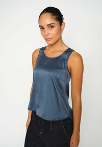 Top senza maniche blu in satin con scollatura arrotondata e design fluido, caratterizzato da una texture liscia e un orlo leggermente curvato.