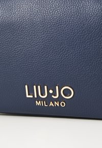Borsa a tracolla in pelle testurizzata blu navy con logo "LIU•JO MILANO" in oro inciso sul davanti, che mette in risalto un design elegante e moderno.