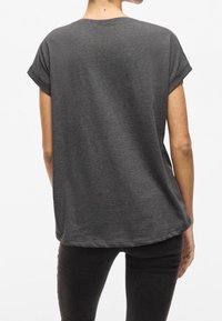 Ciemnoszary t-shirt z krótkim rękawem o luźnym kroju, miękkiej fakturze i zaokrąglonym dolnym obrębie. Podwinięte rękawy i minimalne detale szwów.