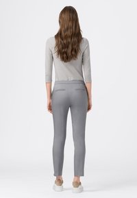 Grå stretchbyxor med slim fit, med bakfickor och en slät, matt textur. Matchas med en randig långärmad topp.