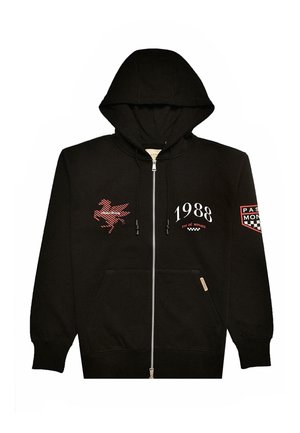 Mustapaita, jossa on vetoketju, valmistettu puuvillasta. Siinä on punainen graafinen suunnittelu, teksti "1988" ja taskut. Mukana on huppu nyöreillä ja logo-patchit.