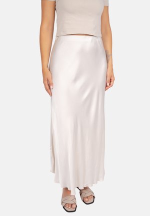 Maxi-Rock aus Satin in sanftem Elfenbein, mit einem fließenden Design, das sanft fällt. Kombiniert mit geflochtenen Sandalen in neutralen Farbtönen.