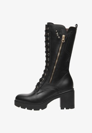 Bota de cuero negro hasta la rodilla con tacón grueso, parte delantera con cordones, cremallera de tono dorado en el lateral y tachuelas decorativas en la parte superior.